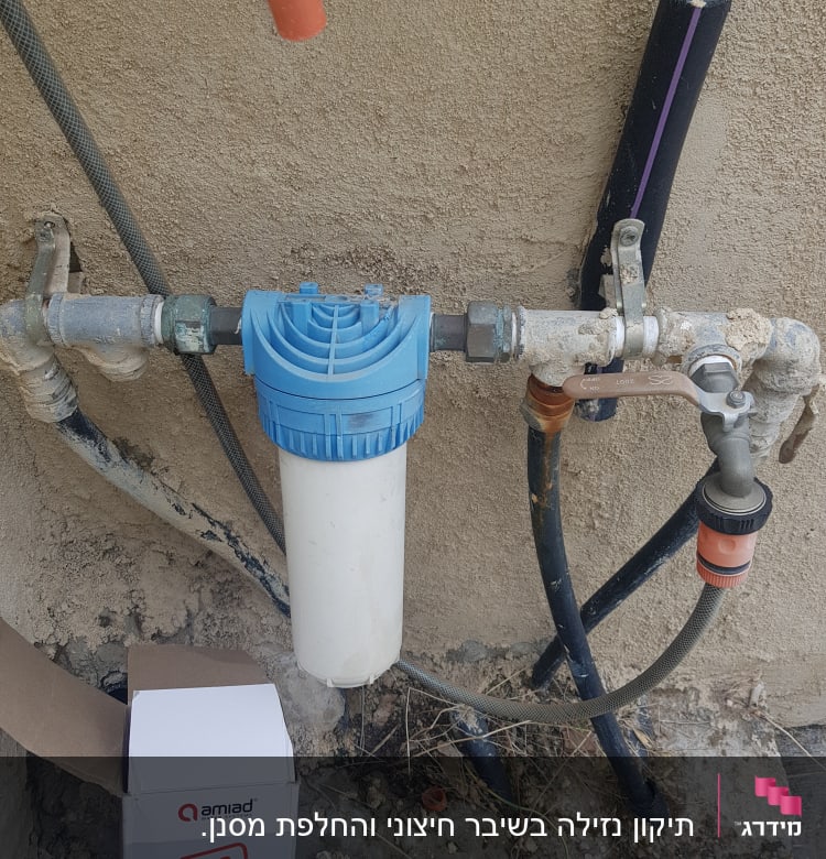 מסנן מים כחול ולבן מחובר לצנרת חיצונית